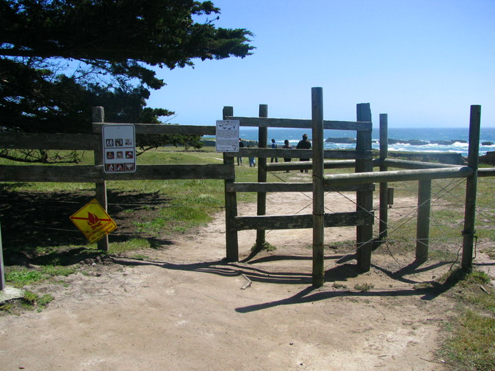 entrance through fence to trail beyond